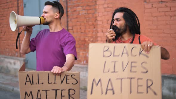 Two Caucasian Men are Protesting in the Street with Megaphones and Signs