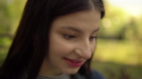 Young Woman Talking By Video Chat in City Park Smiling Girl