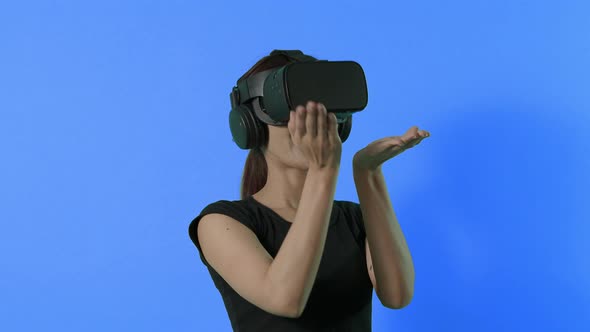 VR game playing. Asian teenager woman playing virtual reality game by VR headset. green screen