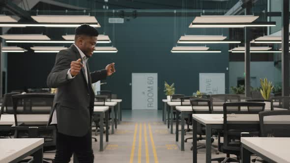 Young Man Multiracial African Employee Manager Entrepreneur Winner Dancing Alone in Modern Office alt