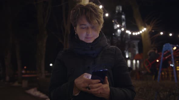 Beautiful Caucasian Woman in Using Smartphone or Cell Phone on the Street alt