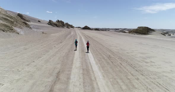 Two women trail runners cross country running in the desert alt