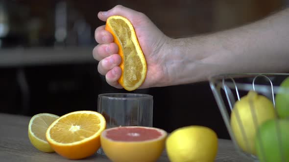 A Man Squeezes Orange Juice with Citrus Juicer alt