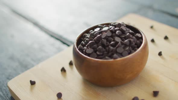 Video of close up of bowl with organic chocolate chip on wooden background alt