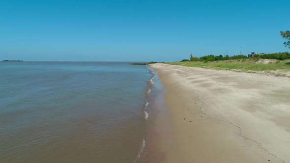 Aerial scene with beach drones. The camera travels forward along the coast. Colonia de Sacramento, U alt