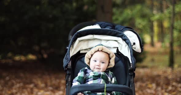 Relaxed Cute Baby Girl in Bow Headband in Baby Carriage.