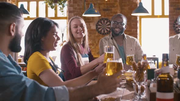 Multiracial people congratulating their friends inside pub