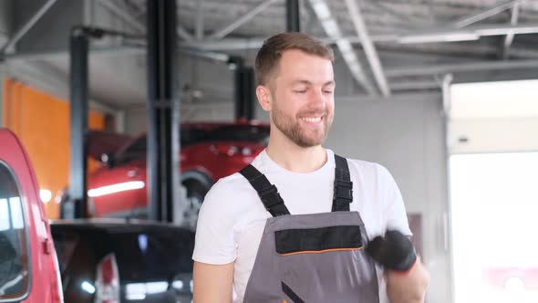Male Car Mechanic Playing with Keys During Lunch Break alt