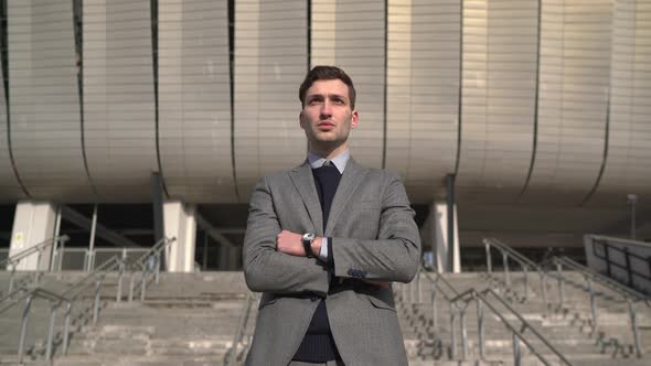 Businessman in suit standing outside the office alt