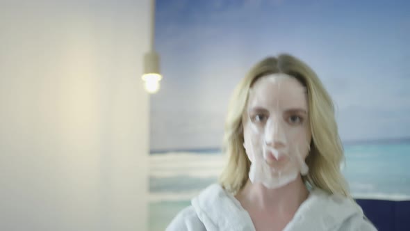 Young blonde caucasian woman re skin care face scrub mask revealing a clean hydrate and brighten ski alt