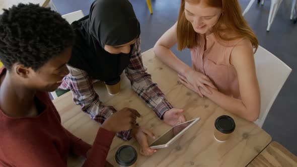 Young adult female friends hanging out in a cafe alt
