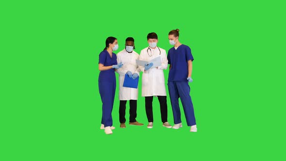 Multiracial Group of Young Doctors Discuss on Documents on a Green Screen Chroma Key