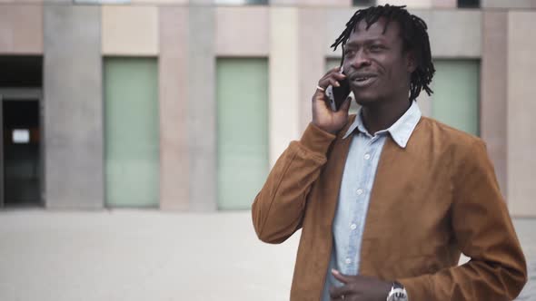 Modern black African Man talking on phone in office corporate business area alt