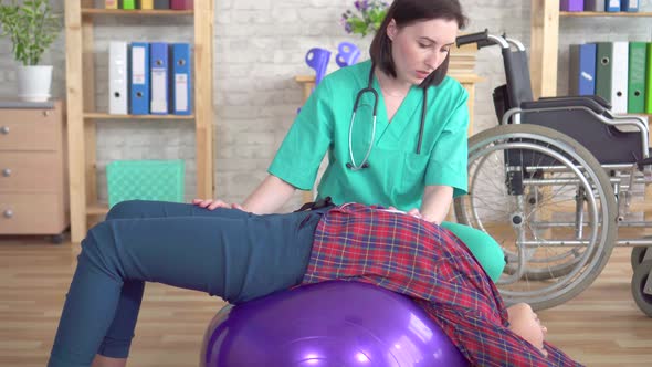Physiotherapist in the Rehabilitation Center Helps a Teenage Girl in Rehabilitation After an Injury alt