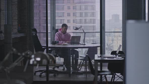 A Young Handsome Man Works in an Office Space alt