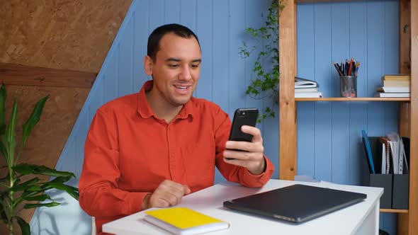 A Young Man Communicates Via Video Link Via Phone with Friends