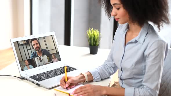 A Young Biracial Woman is Using a Laptop for Video Connection Indoor