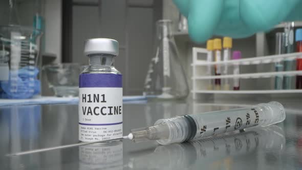 H1N1 vaccine vial in medical lab with syringe placed alt