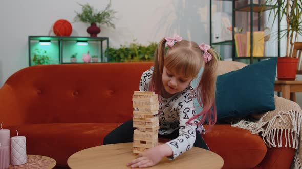 Funny Little One Teen Kid Girl Play Wooden Tower Blocks Bricks Game at Home in Modern Living Room alt