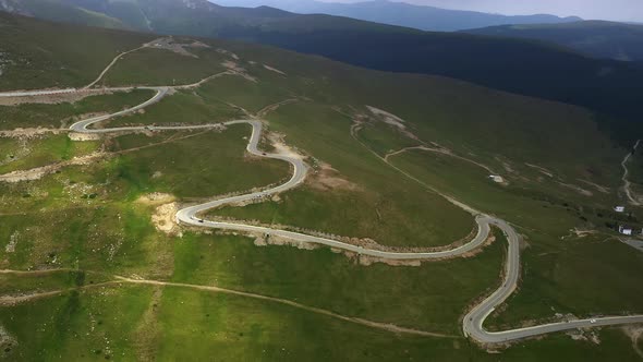 Aerial Shot of Winding Road in Rural Area Surrounded By Green Meadows and Fields Carpathian