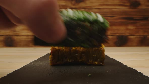 Hand Takes Eastern Sweets on Wooden Background Closeup