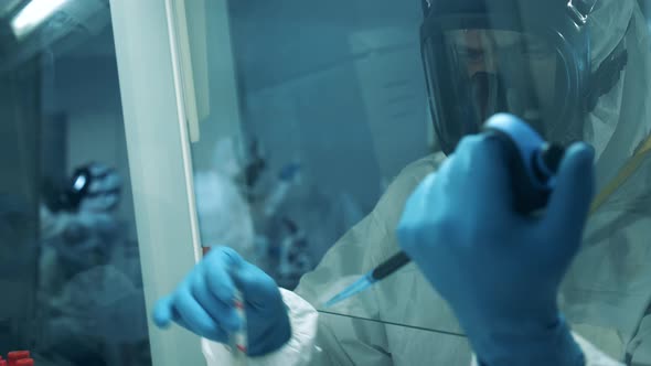 Male Virologist Works with Coronavirus Test in Laboratory. alt