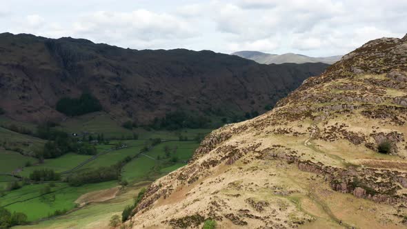 Aerial View Over Hills Towards Mountains