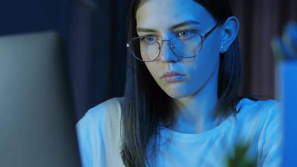 Portrait of Teenage Girl with Glasses Looks at the Monitor alt