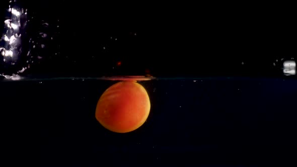500-fps slow motion reverse video of a red tomato splashing into the water. Black background alt
