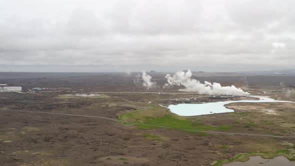 Steam Rising From Hot Springs On A Cloudy Day. Geothermal Landscape In Iceland. wide aerial alt