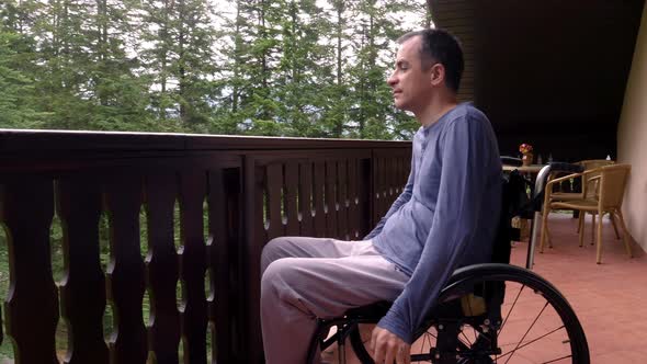 Young Man in Wheelchair Relaxing on Terrace