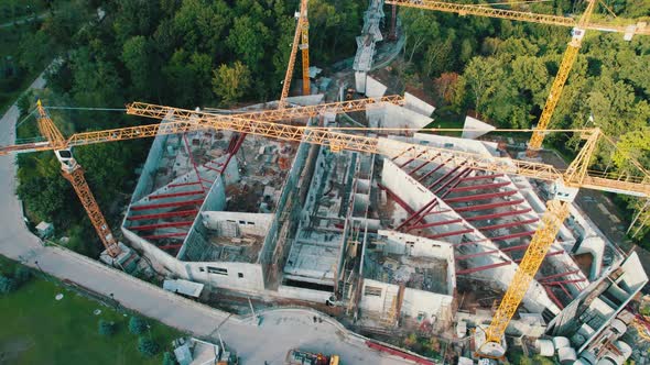 Aerial View Construction of a New Building with High Tower Cranes in Green Area alt