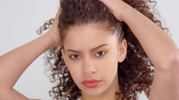 Mixed Race Black Woman with Freckles and Curly Hair in Studio on White Poses To a Camera