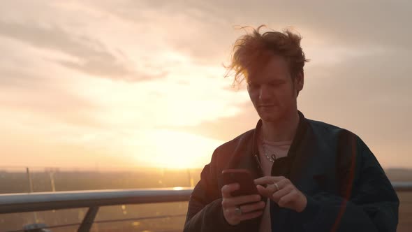 Positive Guy Walking on City Street and Using Cell Phone alt