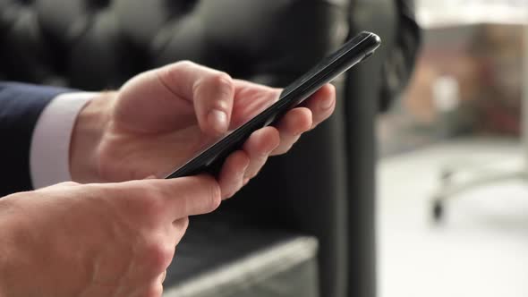 hand of man scrolling the phone screen, searching for information on the Internet