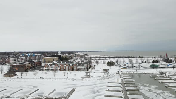 Aerial view toward Lake Michigan. Boats in dry dock. Ice and water in the empty boat slips.