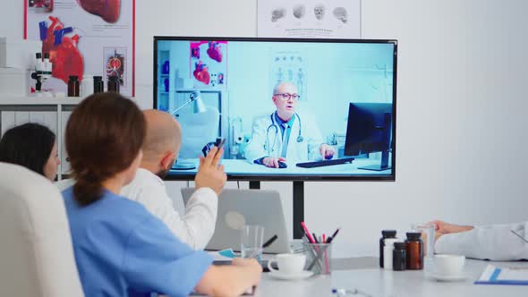 Concentrated Purposeful Experienced Medical Team Holding Online Video Meeting alt