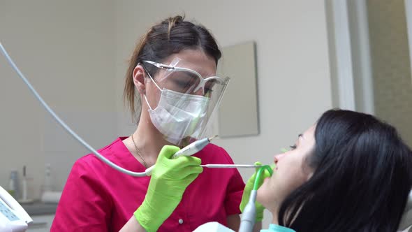 Woman at the Dental Hygienist Getting Professional Tooth Whitening and Ultrasound Cleaning alt