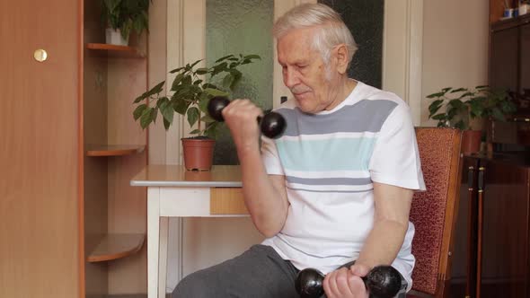 Senior Elderly Caucasian Man Doing Weight Lifting Dumbbell Exercising at Home alt