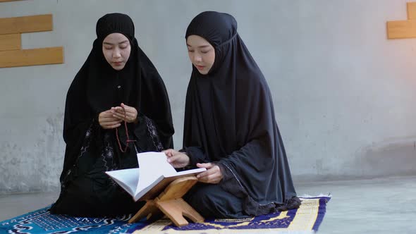 Portrait of an Asian muslim women in a daily prayer at home reciting Surah al-Fatiha passage of the alt
