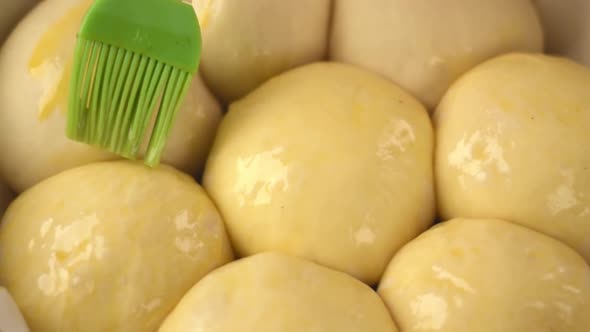 Covering raw yeast buns with egg wash alt