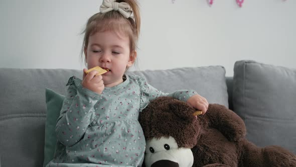 Parentchild Relationship Loving Woman Sits on Daughters Sofa Little Girl Feeds Her Mom with Cookies alt