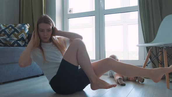 Young and Full of Energy Fit Mother Doing Her Morning Exercises at Home alt