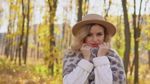 Portrait of a Smiling Happy Cheerful Woman in a Brown Hat in Autumn Park alt