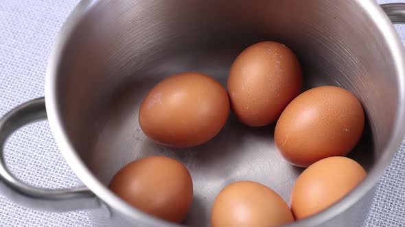 put eggs in a metal saucepan close-up before boiling