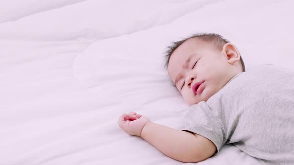 Sleeping cute baby girl on bed during the daytime, Slow motion