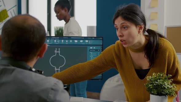 Colleagues Discussing About Industrial Project Analysing 3D Gears alt