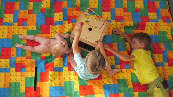 Three children playing with a Montessori toy. Games for brain development. Preschool of life.