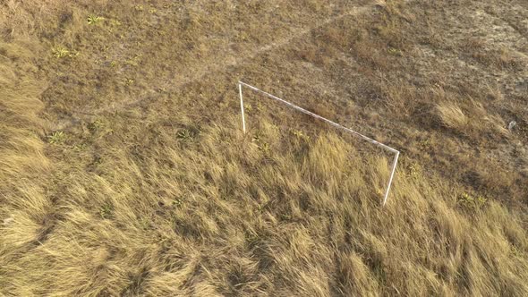 Abandoned soccer goal in the field 4K aerial footage alt