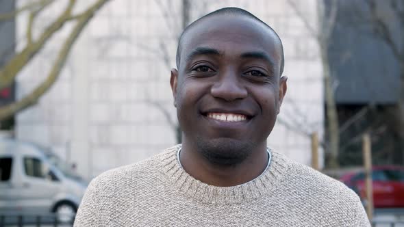 Closeup View of Cheerful Guy Standing and Looking at Camera alt
